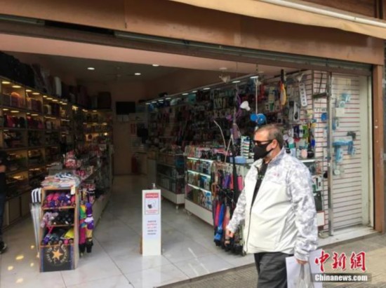 资料图:巴西圣保罗一位男子从一家商店门前走过。<a target='_blank' data-cke-saved-href='http://www.chinanews.com/' href='http://www.chinanews.com/'><p align=