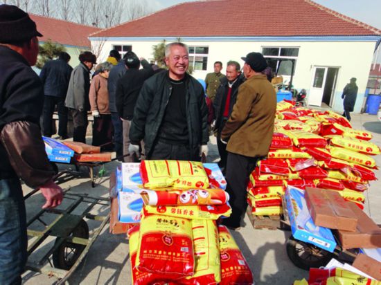 十几年前,日本侨眷丛滋岗在其出生地文登市葛家镇祝家泊子村投资4000多万元成立文登安新食品厂,不但解决了村民的就业问题,还每年为村集体增收20万元,村民增加收入300多万元。丛滋岗还规划投资建设了村委办公室、老年活动中心、卫生院、文化书院、健身广场、路面硬化绿化等。图为2011年1月春节前夕,丛滋岗为村里群众发放年货.jpg